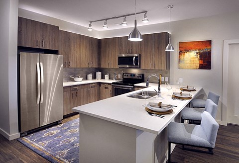 a kitchen with a large island and a stainless steel refrigerator